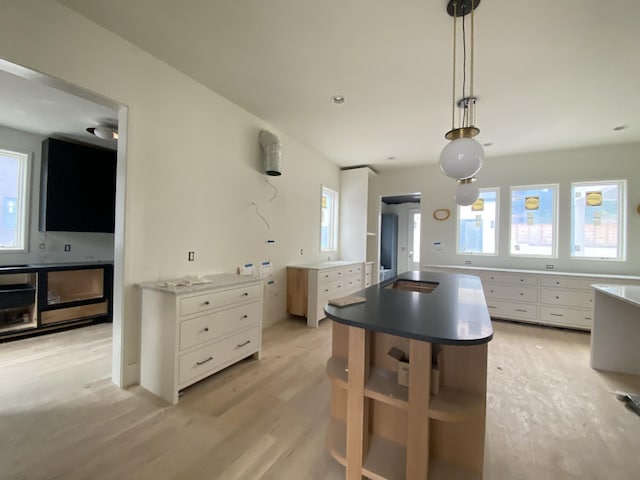 kitchen featuring white cabinetry, pendant lighting, and light wood-type flooring