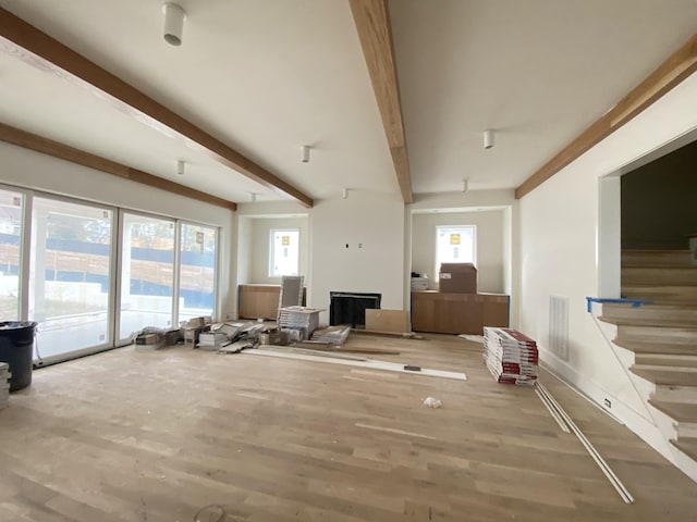 living room with beamed ceiling and light hardwood / wood-style floors