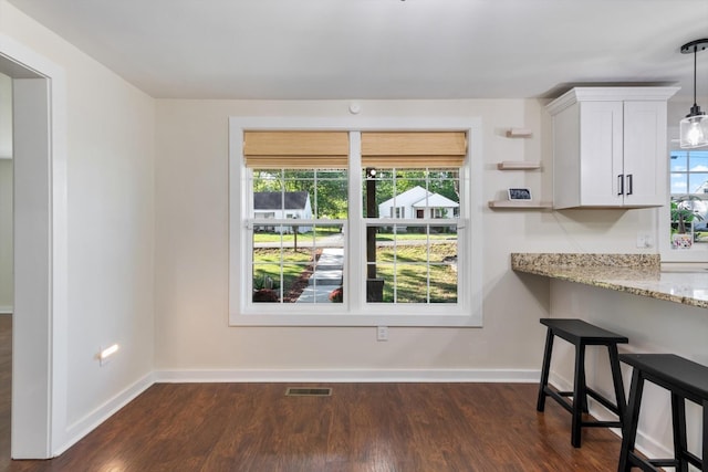 unfurnished dining area featuring dark wood-type flooring