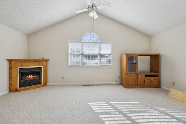 unfurnished living room with vaulted ceiling, light carpet, ceiling fan, and a textured ceiling