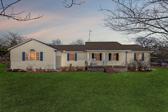 ranch-style house featuring a porch and a lawn