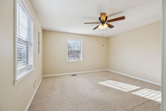 carpeted spare room with ceiling fan and a textured ceiling