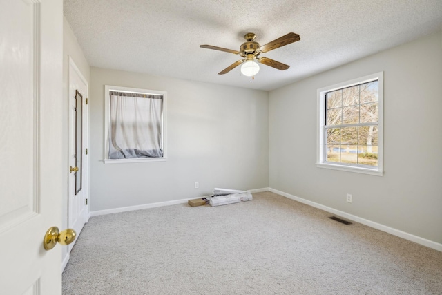 carpeted empty room with ceiling fan and a textured ceiling