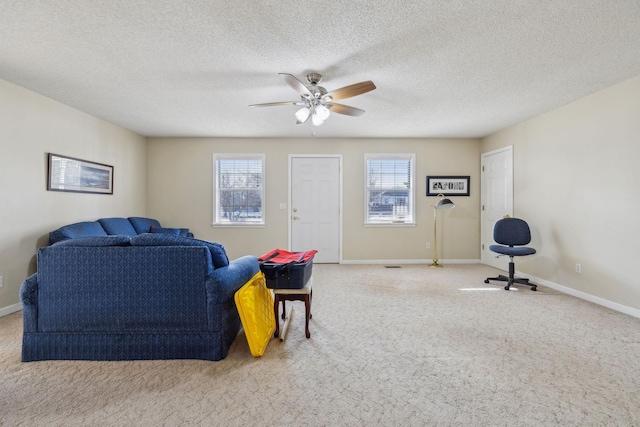 carpeted living room with ceiling fan and a textured ceiling