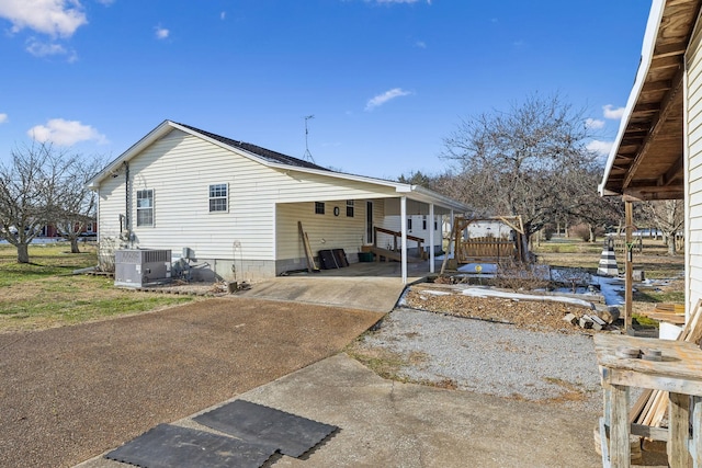 rear view of property with cooling unit and a carport