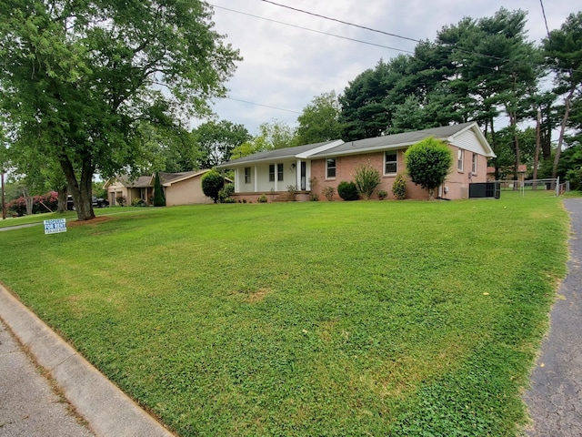 ranch-style home with a front yard and cooling unit