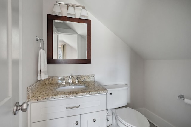 bathroom with vanity, vaulted ceiling, and toilet