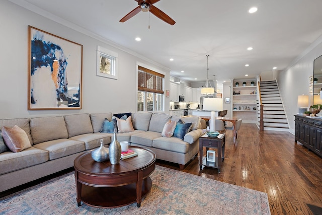 living room featuring dark hardwood / wood-style flooring, ornamental molding, and ceiling fan