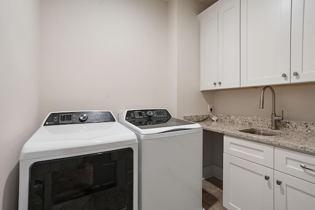 laundry area with washer and dryer, sink, and cabinets