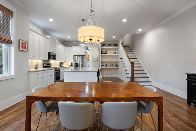 dining room with ornamental molding and dark hardwood / wood-style floors