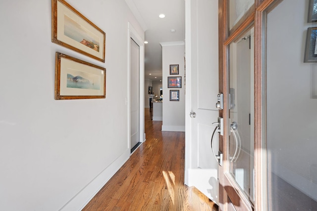 hall with ornamental molding and hardwood / wood-style floors