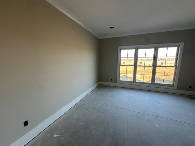 empty room with ornamental molding and concrete flooring