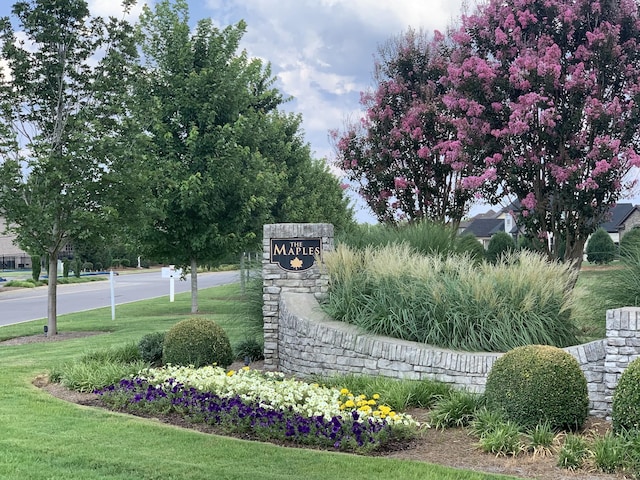 community / neighborhood sign featuring a yard