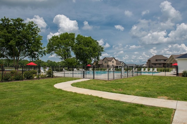 view of property's community featuring a pool and a yard