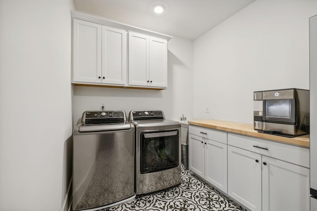 washroom featuring cabinets, independent washer and dryer, and light tile patterned flooring