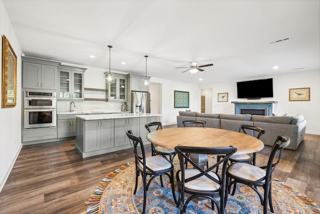 dining room featuring dark wood-type flooring, sink, and ceiling fan