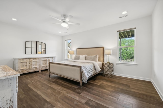 bedroom with multiple windows, dark hardwood / wood-style flooring, and ceiling fan