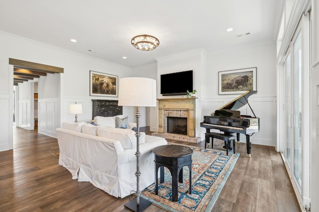 living room with a brick fireplace, hardwood / wood-style flooring, and ornamental molding