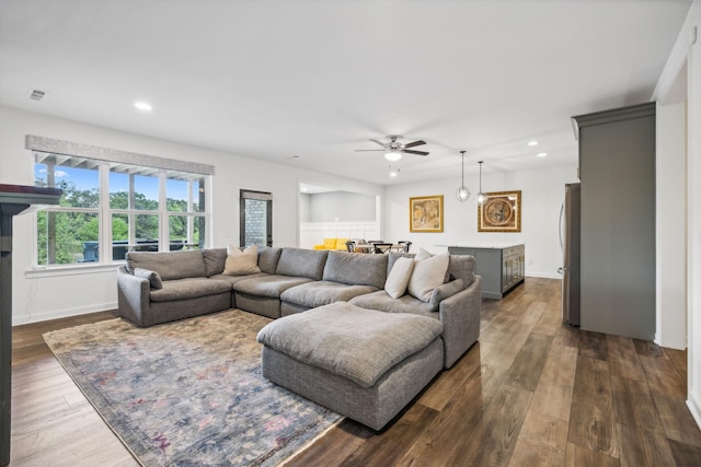 living room with dark wood-type flooring and ceiling fan