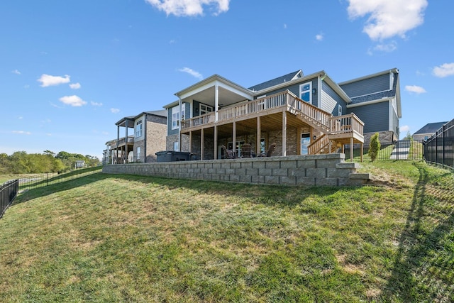 rear view of property with a wooden deck and a lawn