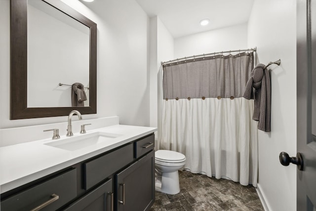 bathroom featuring vanity, walk in shower, and toilet