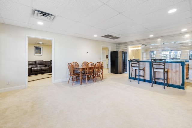 carpeted dining space featuring a drop ceiling