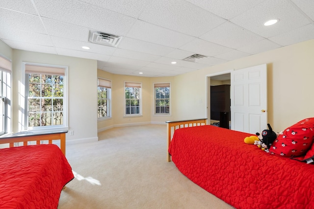 carpeted bedroom with a drop ceiling