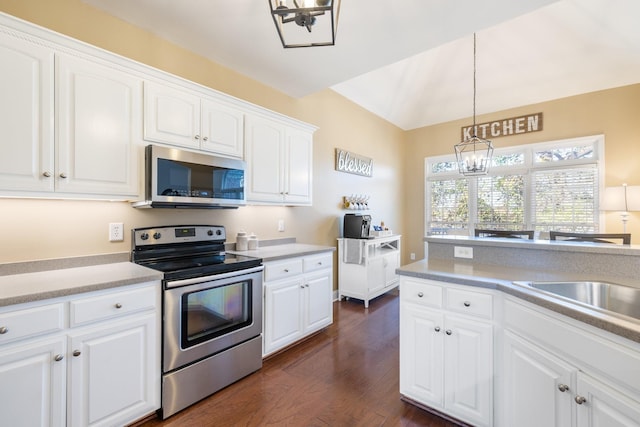 kitchen featuring dark wood-type flooring, white cabinetry, appliances with stainless steel finishes, a notable chandelier, and pendant lighting