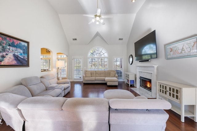 living room with ceiling fan, high vaulted ceiling, dark hardwood / wood-style floors, and a fireplace