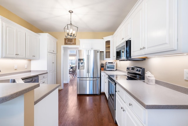 kitchen with decorative light fixtures, dark wood-type flooring, stainless steel appliances, and white cabinets