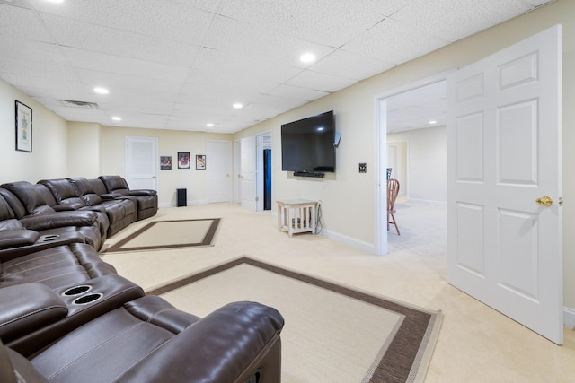 carpeted living room with a paneled ceiling