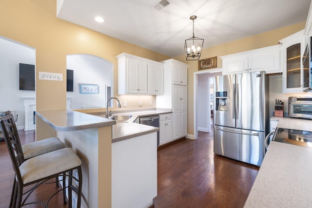 kitchen with decorative light fixtures, sink, white cabinets, dark hardwood / wood-style flooring, and stainless steel appliances