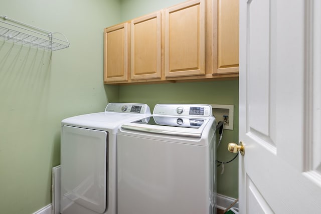 clothes washing area with cabinets and independent washer and dryer