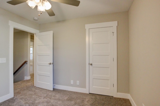 unfurnished bedroom with ceiling fan and light colored carpet