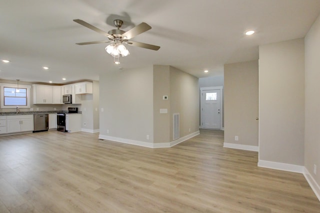 unfurnished living room featuring ceiling fan, a healthy amount of sunlight, and light hardwood / wood-style flooring