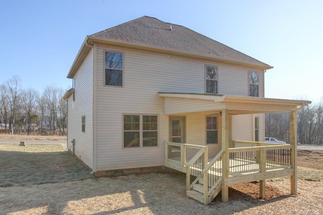 rear view of house featuring a wooden deck