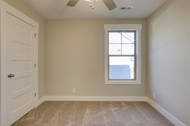 spare room with ceiling fan and carpet