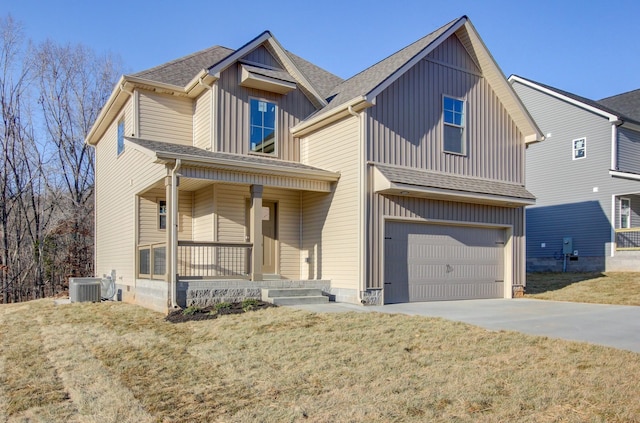 view of front of house featuring cooling unit, a porch, a garage, and a front lawn