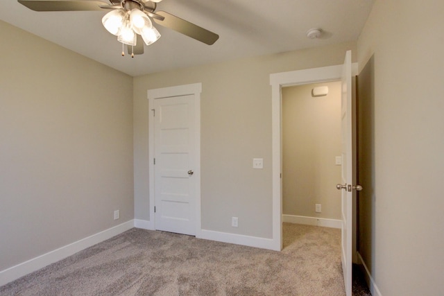 unfurnished bedroom with ceiling fan, a closet, and light carpet