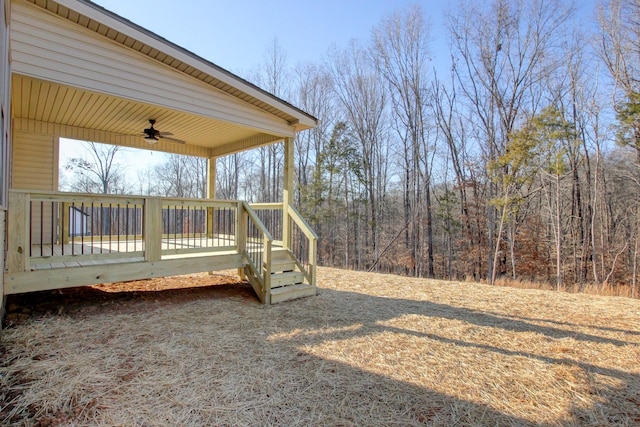 view of yard with a wooden deck and ceiling fan