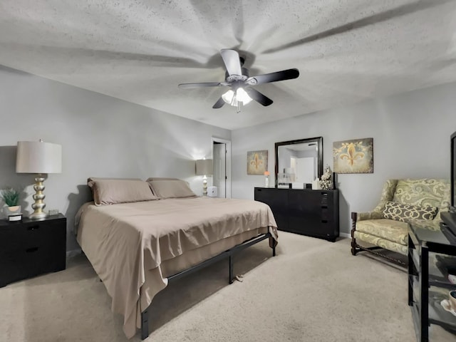 carpeted bedroom with ceiling fan and a textured ceiling