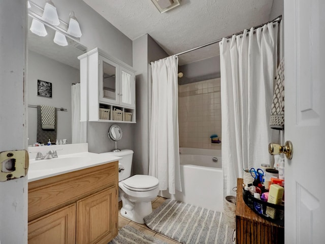 full bathroom featuring shower / bathtub combination with curtain, vanity, a textured ceiling, tile patterned floors, and toilet