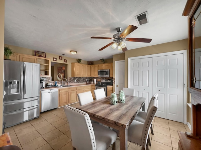 kitchen featuring light brown cabinetry, tasteful backsplash, sink, light tile patterned floors, and stainless steel appliances