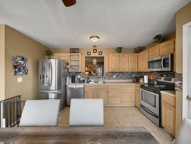 kitchen featuring stainless steel appliances, light brown cabinetry, sink, and light tile patterned floors