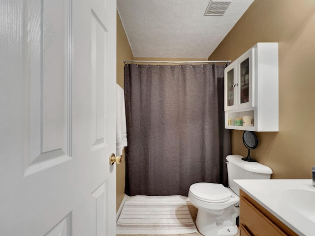 bathroom with vanity, a textured ceiling, and toilet