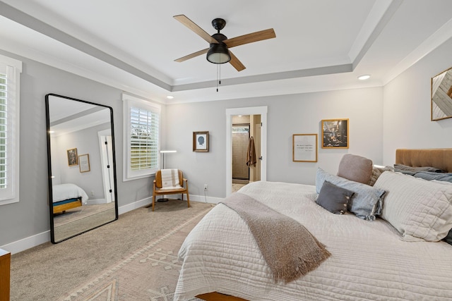 carpeted bedroom featuring crown molding, ceiling fan, and a raised ceiling