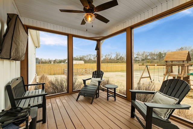 sunroom featuring a rural view and ceiling fan