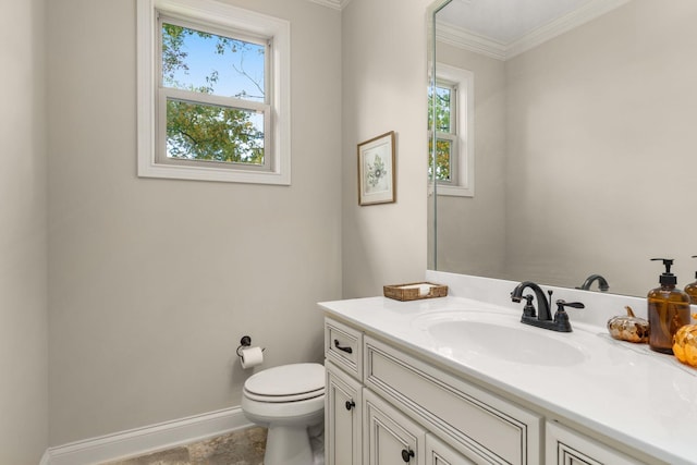 bathroom with ornamental molding, vanity, and toilet