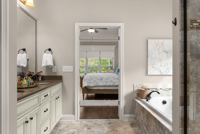 bathroom featuring a relaxing tiled tub, ornamental molding, and vanity