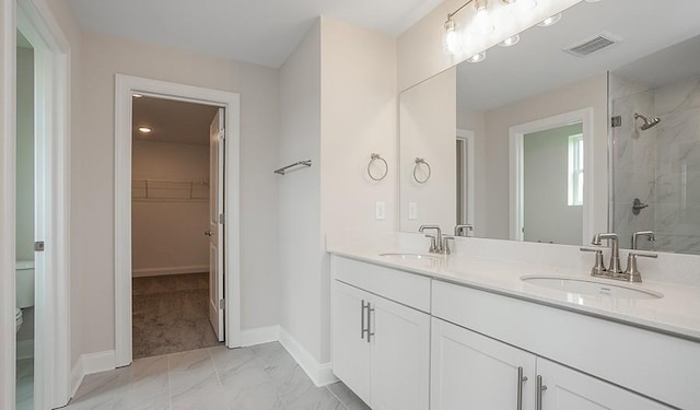 bathroom with vanity, a shower with shower door, and toilet